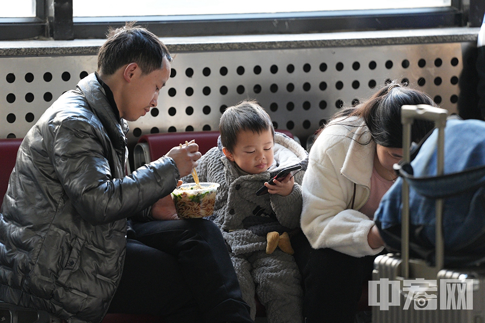 小朋友一边吃饭，一边不忘盯着手机。 中宏网记者 富宇 摄