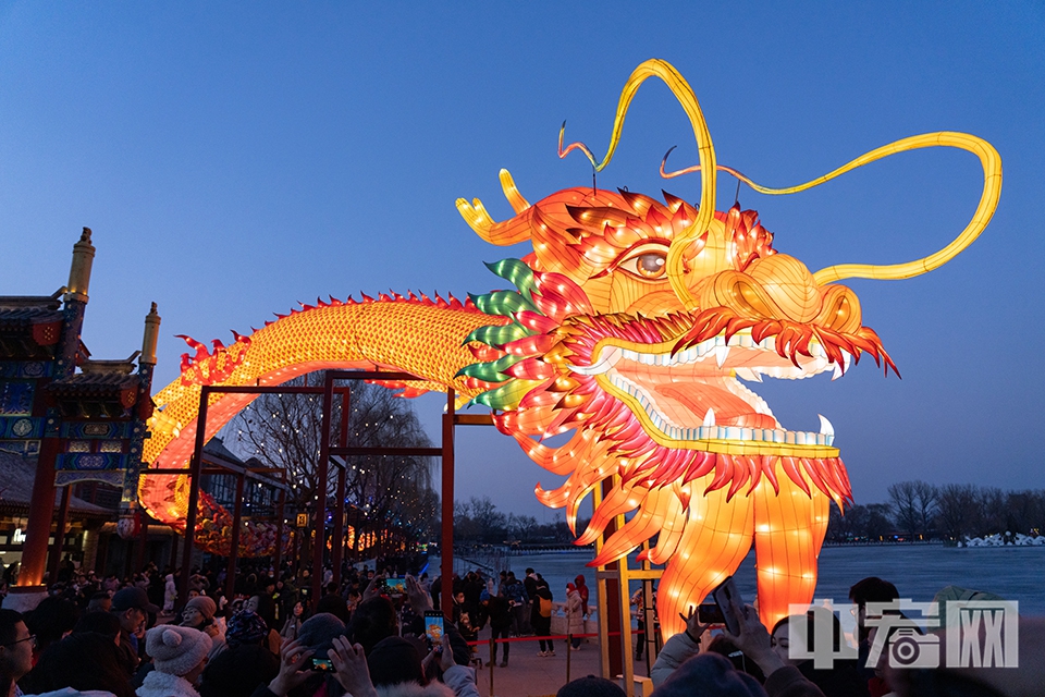 2月10日大年初一，在北京什刹海畔荷花市场上空的一条200余米的“蛟龙出海”巨型龙灯点亮，吸引众多市民游客驻足围观。 中宏网记者 富宇 摄