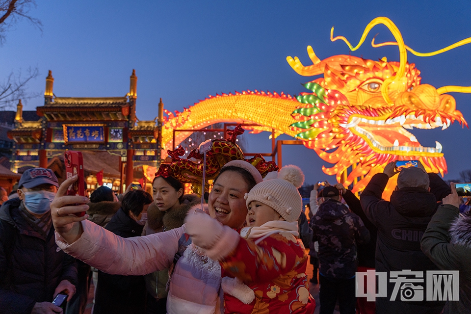 2月11日，游客在北京什刹海巨型龙灯前拍照留念。