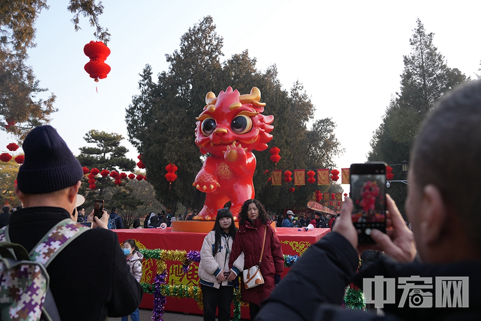 游客同地坛庙会的龙年吉祥物合影。 中宏网记者 富宇 摄