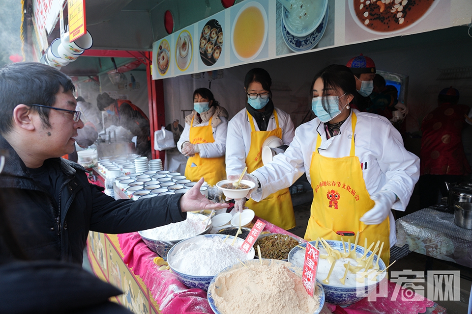 游客在庙会上品尝各种小吃，来一碗热腾腾的茶汤。 中宏网记者 富宇 摄