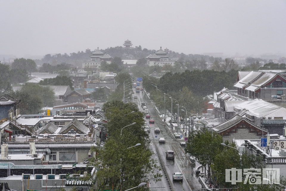 圖為雪后的鼓樓大街，遠處是中軸線景山萬春亭。