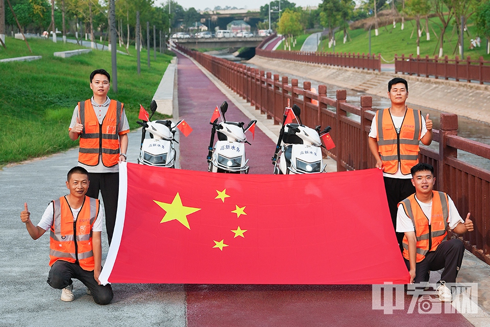 成都水务河道管理人员与国旗合影。 成都高投城市资源经营有限公司 供图