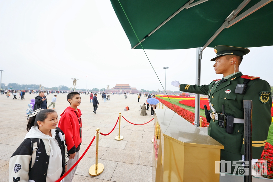 国庆长假期间，每天都有来自全国各地的数万群众齐聚天安门广场。为了保证人民群众的安全，武警北京总队执勤第一支队的官兵们值守在人流密集区域的安检口、地下通道、金水桥、故宫博物院入口等重点位置，有效对人员密集区域进行快速疏导，确保游客安全参观游览，并耐心地为游客们解答问题。陈硕 摄