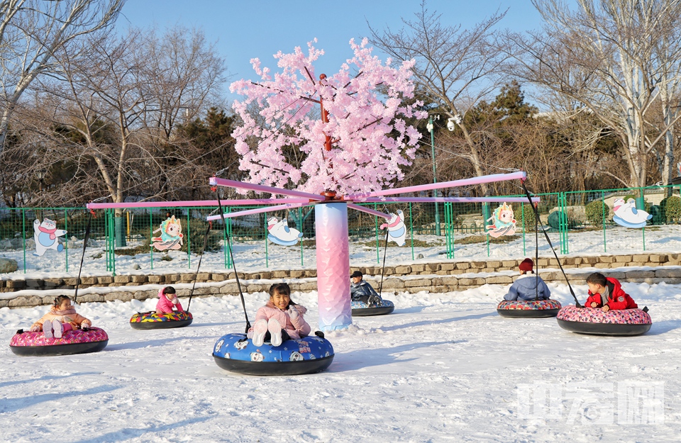 小朋友在玉淵潭公園冰雪季上玩雪圈。