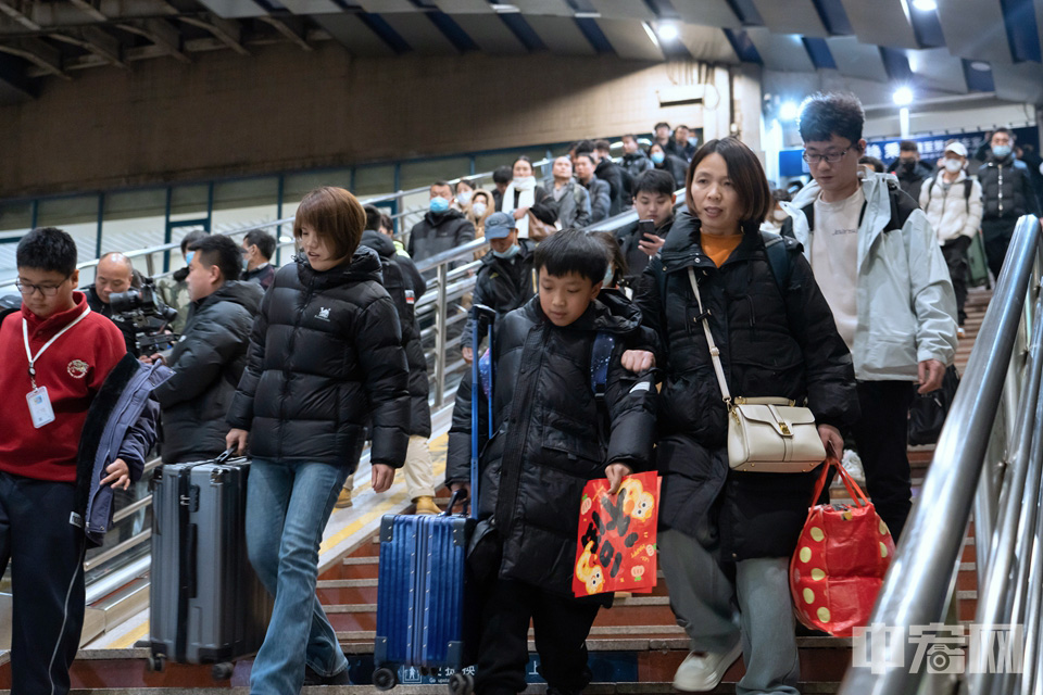 乘坐春運(yùn)首日北京地區(qū)首趟旅客列車K4159次的乘客有序進(jìn)站。