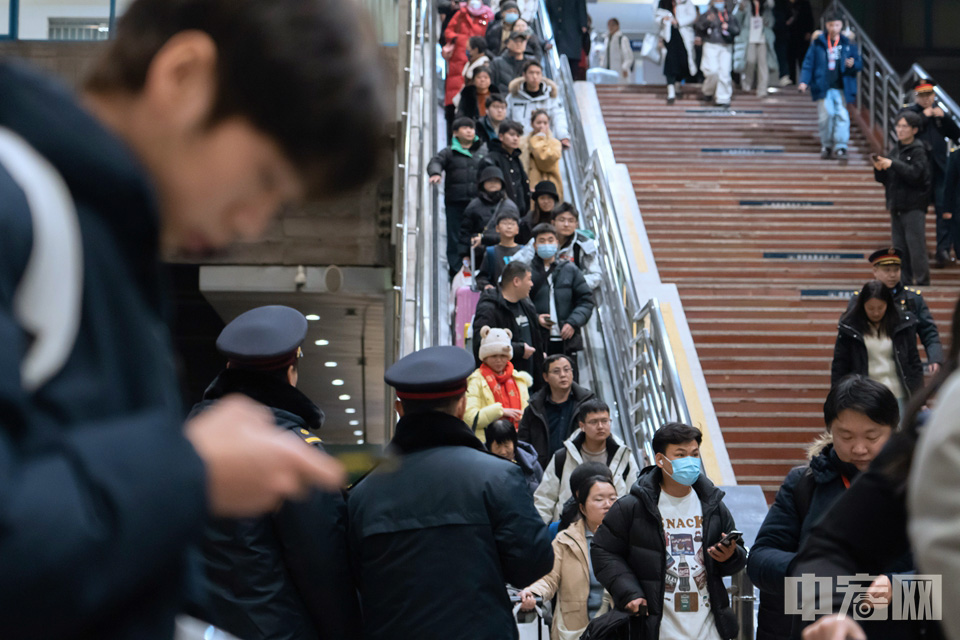 乘坐春運(yùn)首日北京地區(qū)首趟旅客列車K4159次的乘客有序進(jìn)站。