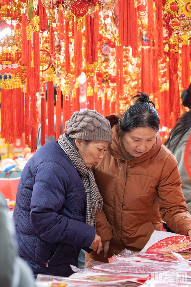 随着春节的脚步日益临近，京城的年货消费持续升温。位于全国农业展览馆的老北京年货大集热闹非凡，人气爆棚。传统年货琳琅满目，从火红的灯笼、精美的窗花到各式各样的干果糖果，每一处都洋溢着浓浓的年味。