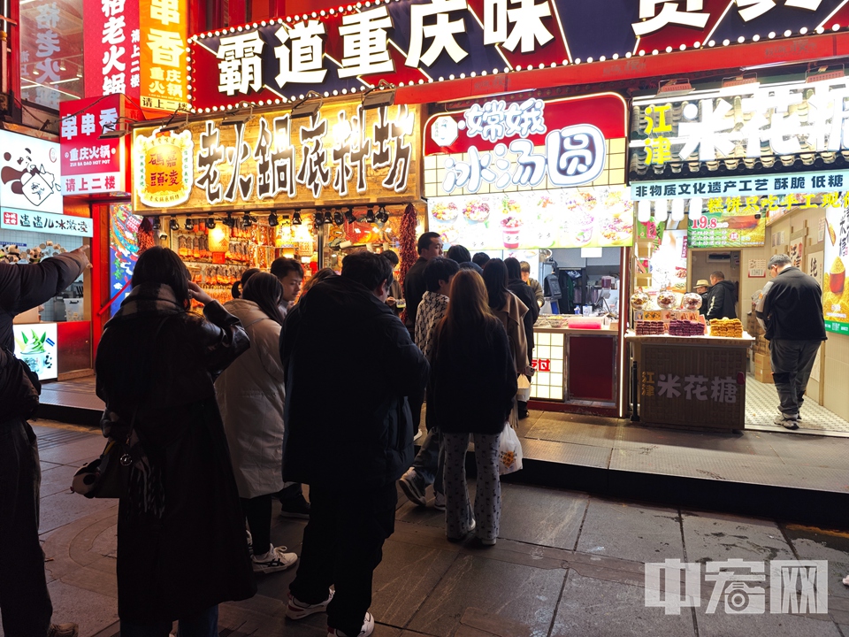 民众在特色美食冰汤圆的摊位前排起长队。 张帆 摄