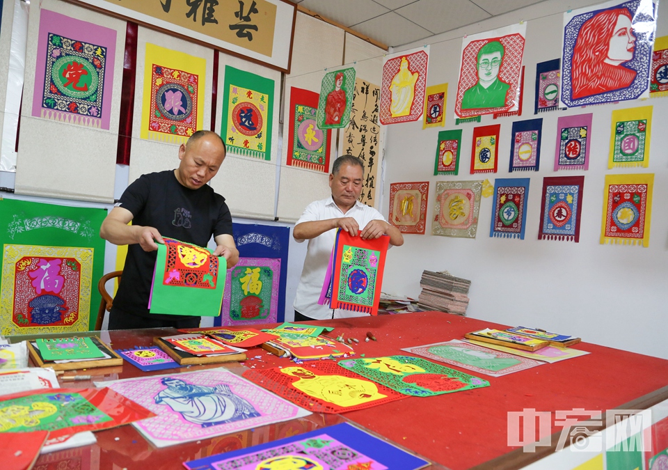 村支書張立和張乃蒼將制作好的掛門箋整理打包。 李結義 攝