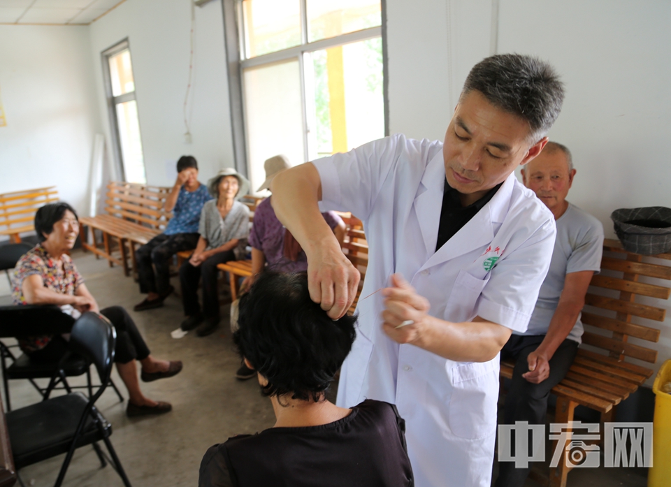 韓洪光正在為群眾進行針灸治療。 李結(jié)義 攝