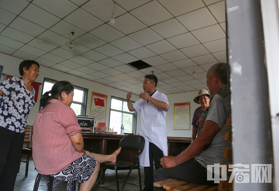 現(xiàn)場，韓洪光耐心為村民把脈問診，針對常見病、慢性病提出中醫(yī)調(diào)理方案，并普及中醫(yī)藥養(yǎng)生知識，受到村民熱烈歡迎。 李結(jié)義 攝
