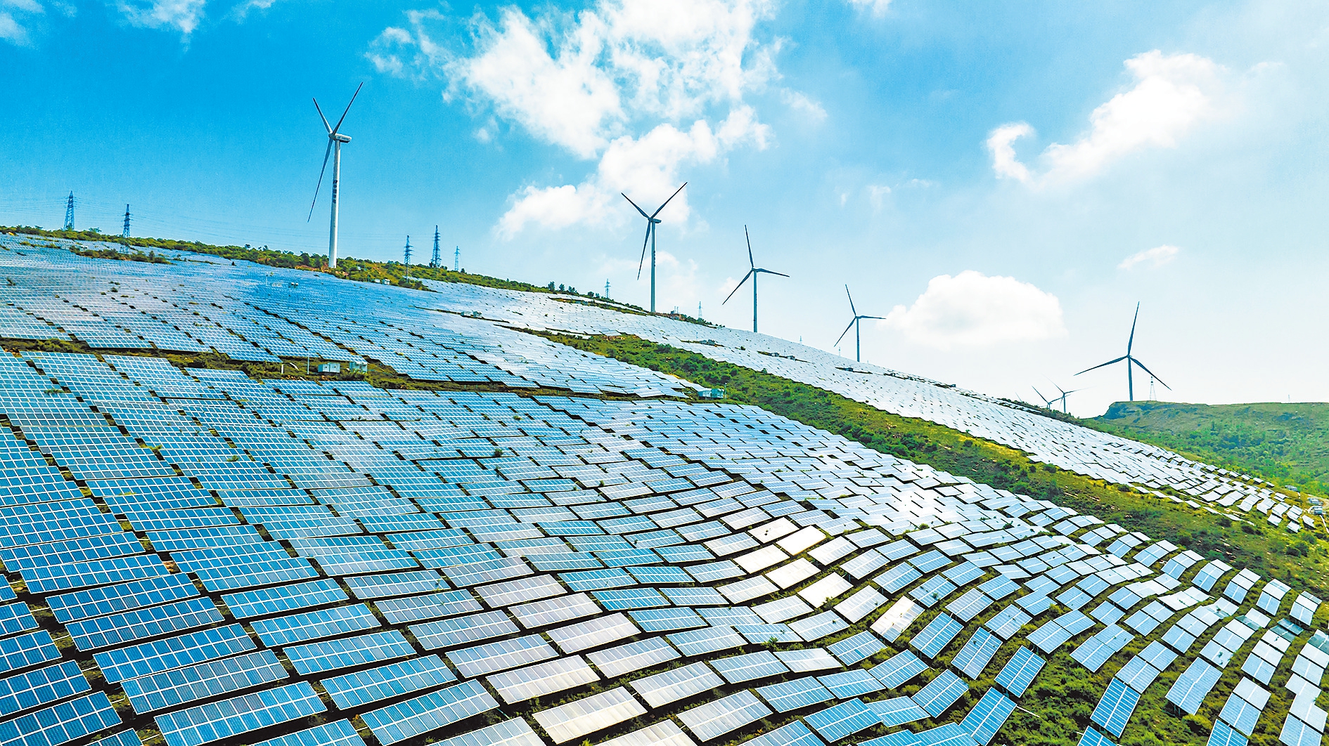 5月30日，宜陽縣錦屏山生態公園南麓，光伏太陽能電池板和風電機組在藍天白云映襯下，形成一道清新亮麗的風景線。 田義偉 攝