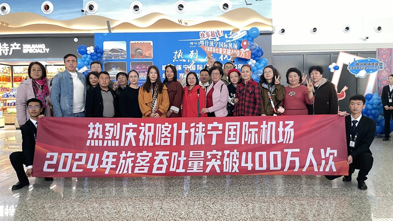 喀什徕宁国际机场旅客吞吐量突破400万人次活动现场，旅客和工作人员合影留念。马丽娜 摄.JPG